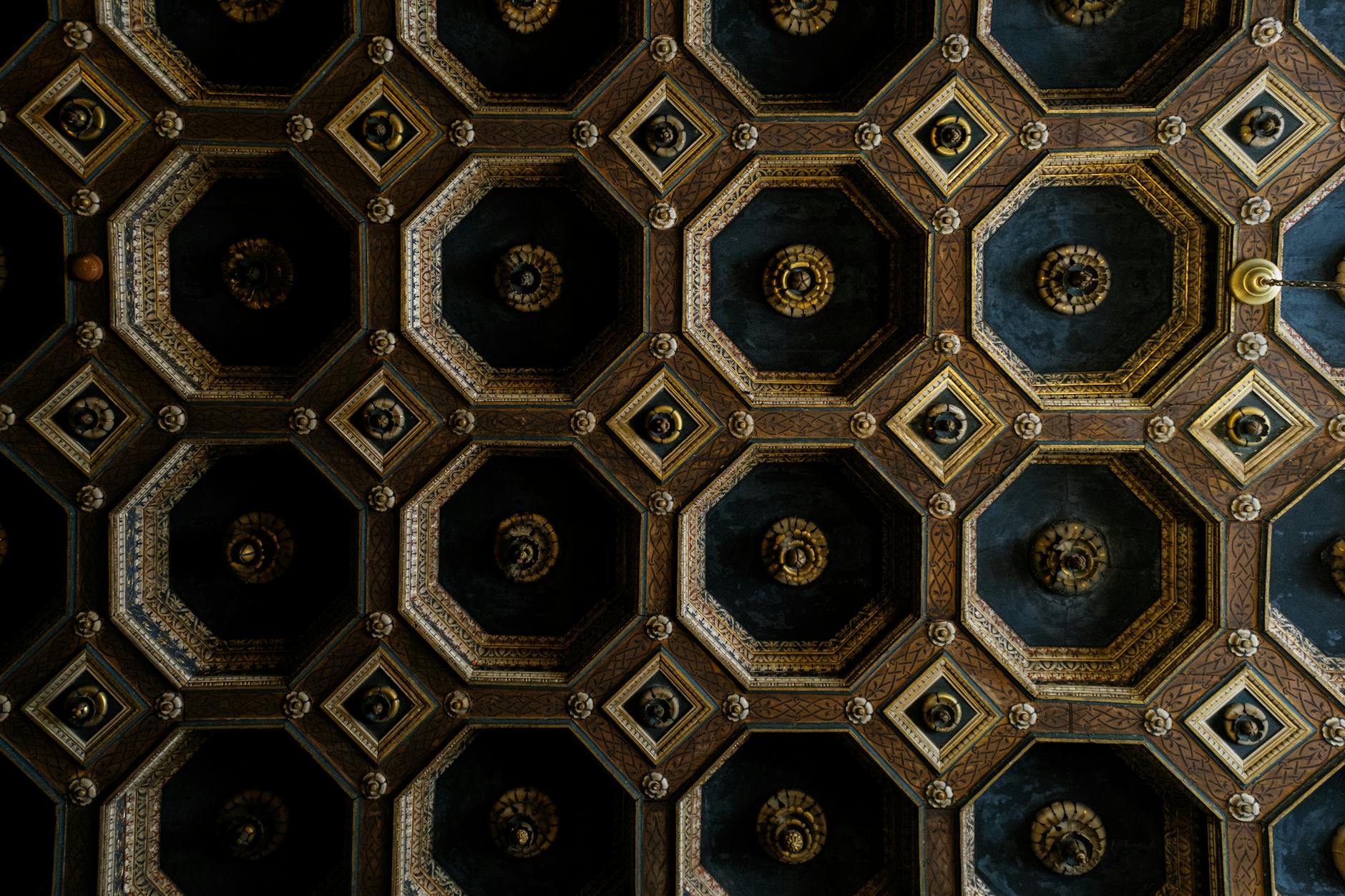 the ceiling of a building with a pattern of gold and black